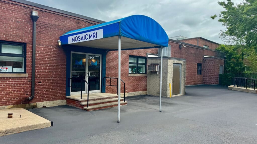 Mosaic diagnostic imaging center entrance, brick building with blue canopy sign, outpatient MRI services offered.